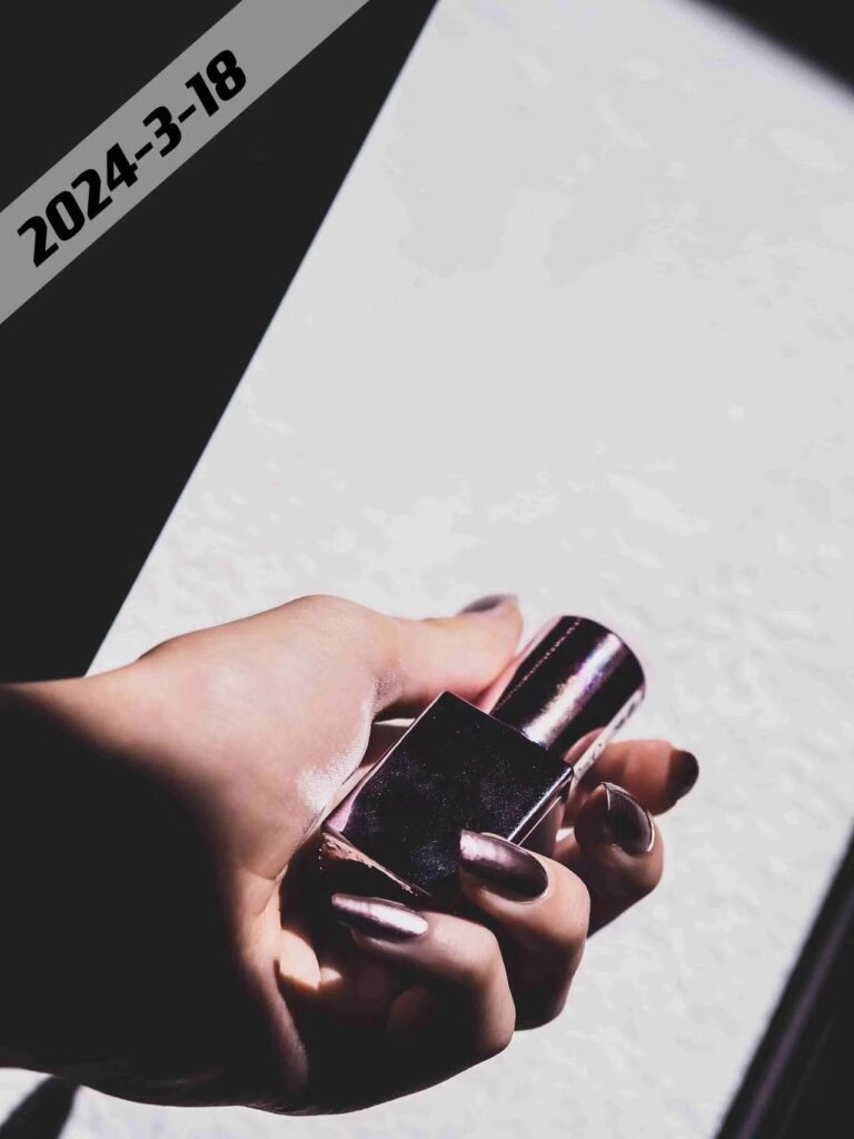 a hand holding a nail polish bottle