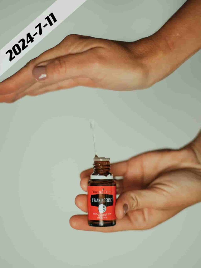 Hands holding and dispensing oil from a small bottle