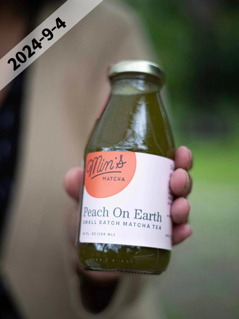 a woman holdig a glass bottle of juice